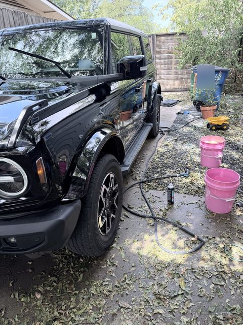 A black Ford Bronco mid wash with buckets, in a North Austin driveway