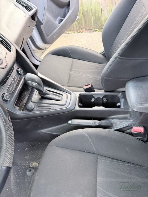 Centre console and gear selector of a Ford Focus before cleaning, dust in every seam